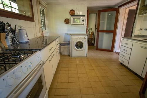 a kitchen with a washer and dryer in it at Casa en Llao Llao con vista al lago y campo de golf in San Carlos de Bariloche