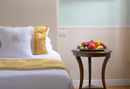a plate of fruit on a table next to a bed at Hotel Palazzo Vitturi in Venice