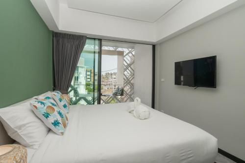 Un dormitorio con una gran cama blanca y una ventana en Yanud Residence, en Phuket