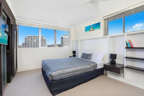 a bedroom with a bed and a large window at Elouera Tower in Maroochydore