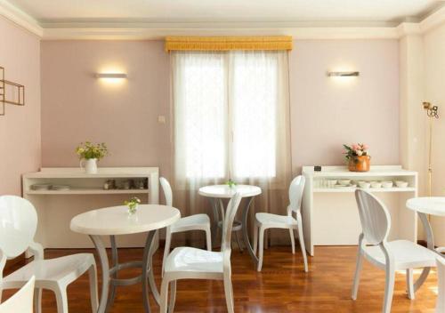 a dining room with white tables and white chairs at BYPILLOW Villa Lorena Adults Recommended in Málaga