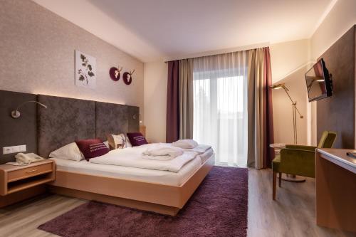ein Hotelzimmer mit einem großen Bett und einem Fenster in der Unterkunft Das Steinberger in Altlengbach