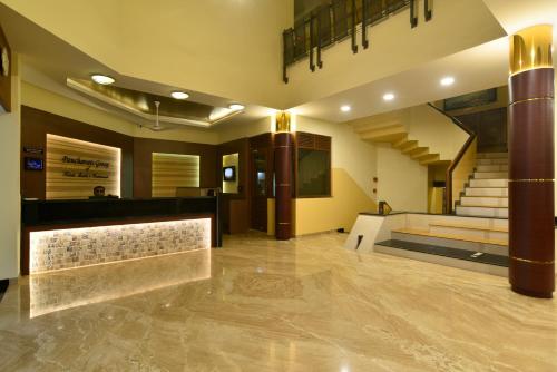 a lobby of a building with a staircase in the background at Panchavati Elite Inn in Nashik