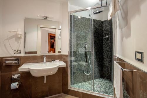 a bathroom with a shower, sink, and tub at Best Western Hotel Astrid in Rome