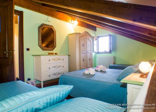 a bedroom with two twin beds and a dresser at Il Casolare Bioenergetico in Albareto