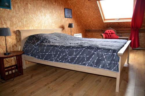 - une chambre avec un lit et une couette bleue dans l'établissement Gîte le Manège Normand, à Grand Camp