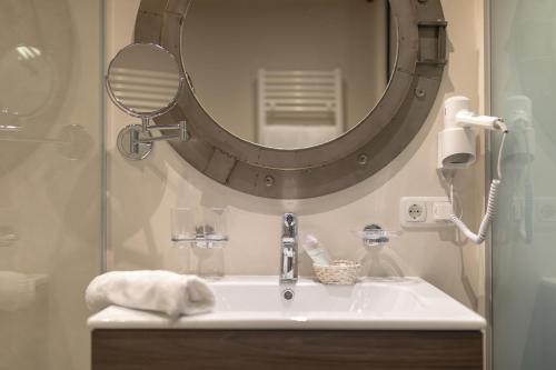 a bathroom with a sink and a large mirror at Hotel Landhaus Carla in Mayrhofen