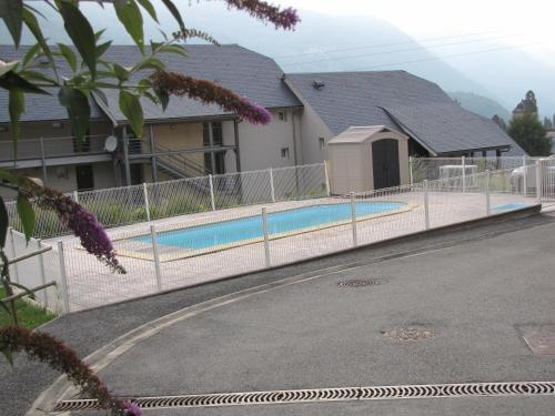 une clôture autour d'une piscine en face d'une maison dans l'établissement T2 de L'yse, à Luz-Saint-Sauveur