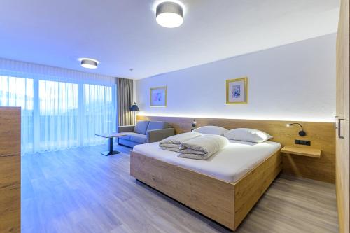 フューゲンベルクにあるResidenz Schiestlのベッドとデスクが備わるホテルルームです。