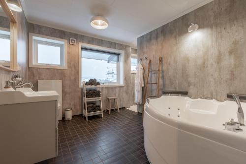 a bathroom with a large tub and a sink at Sagi 3 Exclusive Private Apartment in Hafslo