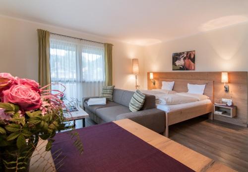 - un salon avec un canapé et un lit dans une chambre dans l'établissement Ferienwohnungen Trinkl, à Bad Wiessee