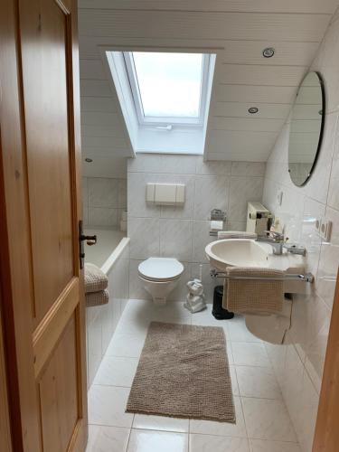 a bathroom with a sink and a toilet and a skylight at Ferienwohnung Jauß in Baierbrunn