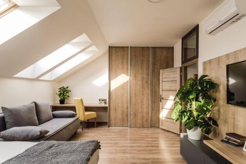 a room with a bed and a couch and a desk at FLEXIHOME SK - Komenskeho - private parking spot - ultra modern and stylish in Košice