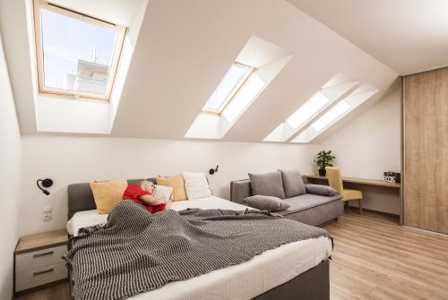 a living room with a bed and a couch at FLEXIHOME SK - Komenskeho - private parking spot - ultra modern and stylish in Košice
