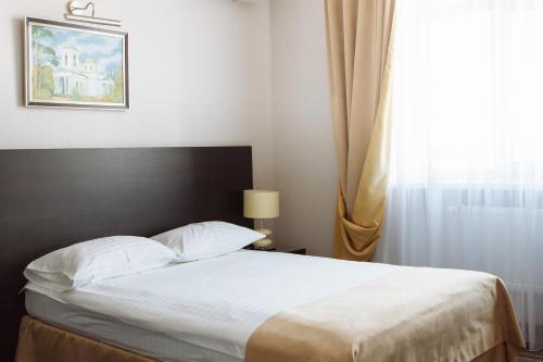 a bedroom with a large bed with a window at Optima Sumy in Sumy