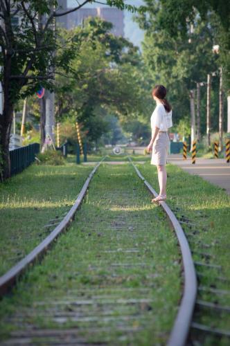 a woman standing on train tracks in a park at Otaru Tap Room & Hostel in Otaru
