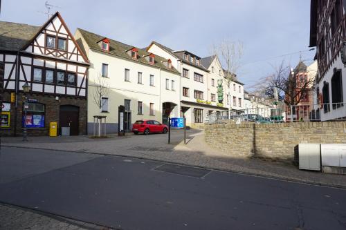 una calle con edificios y un coche rojo en la calle en Hotel-Restaurant Weinhaus Grebel, en Coblenza