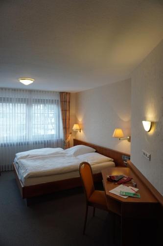 a hotel room with a bed and a desk and a table at Hotel-Restaurant Weinhaus Grebel in Koblenz