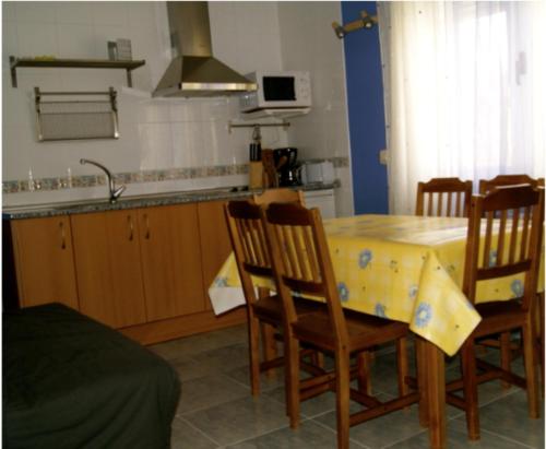 cocina con mesa, sillas y fregadero en Apartamentos El Castañar, en Hervás