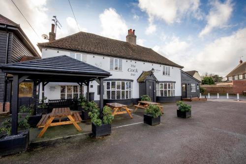 a white building with a picnic table in front of it at The Cock Inn Hotel in Sheering