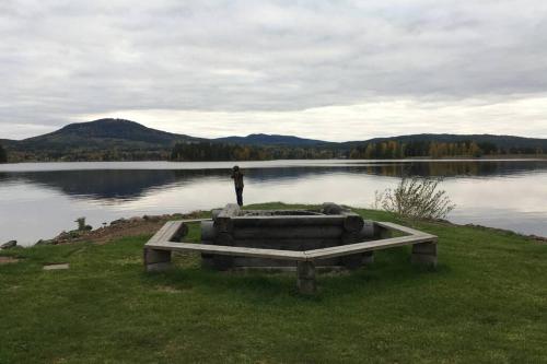 a man standing on the edge of a body of water at Dalastugan in Mora
