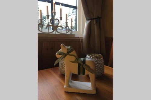 a wooden horse with a bow on the floor next to a chandelier at Dalastugan in Mora