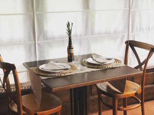 a table with two chairs and a table with plates and glasses at Hotel Rural Casona Trabadelo in Vegadeo