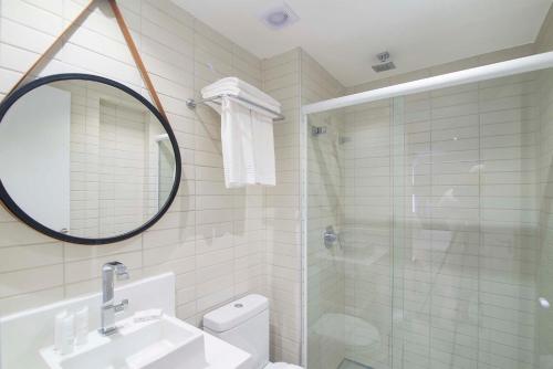uma casa de banho com um chuveiro, um lavatório e um espelho. em Infinity at the Sea by Welkom em João Pessoa