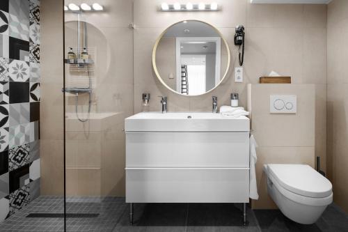 W łazience znajduje się umywalka, toaleta i lustro. w obiekcie Jobelhome Apartments w Budapeszcie