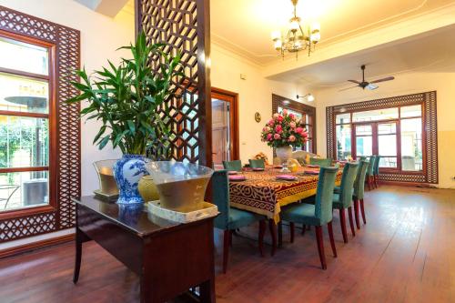 a dining room with a table and green chairs at Aisha HOTELS and APARTMENTS in Hanoi