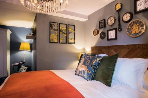 a bedroom with a bed with clocks on the wall at Hotel Indigo - Stratford Upon Avon by IHG in Stratford-upon-Avon