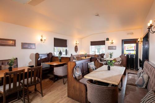 a restaurant with tables and chairs in a room at The Cock Inn Hotel in Sheering