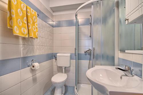 uma casa de banho com um WC, um lavatório e um chuveiro em Apartments Gilly 1 em Premantura