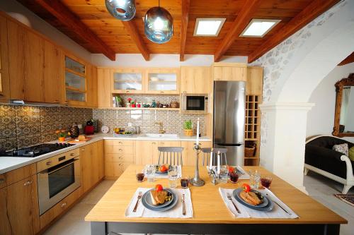 a kitchen with wooden cabinets and a table with food on it at Hawk Villa, nature essence, By ThinkVilla in Yerakárion