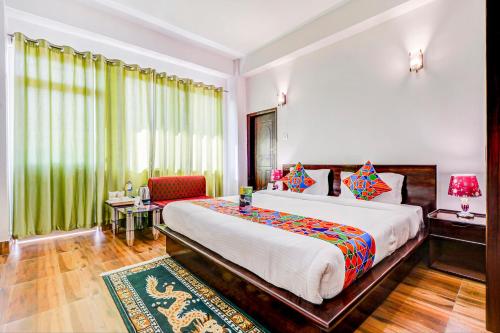 um quarto com uma cama grande e uma cadeira em FabHotel Greenery View Middle Lingding ICAR Road em Gangtok