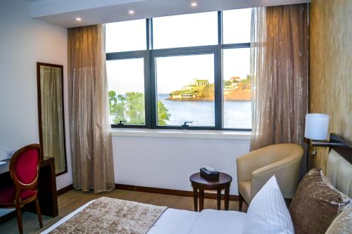 a hotel room with a large window with a view of the water at Mamba Point Hotel in Freetown