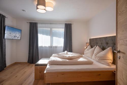 a bedroom with a large bed with a window at Apart Platzer in Zell am Ziller