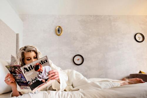 a woman laying in bed reading a magazine at The Starling Atlanta Midtown, Curio Collection by Hilton in Atlanta