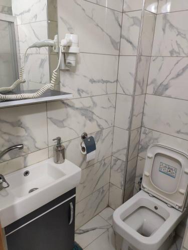 a white bathroom with a sink and a toilet at Moon Suit Hotel in Istanbul