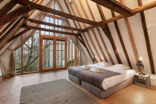 a bedroom with a bed in a room with wooden ceilings at Lovely Jordaan Home in Amsterdam