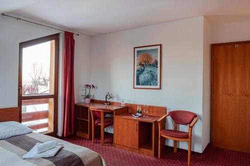 a hotel room with a bed and a desk and a table at Penzión Borievka in Poprad