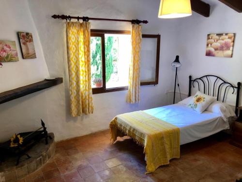 Schlafzimmer mit einem Bett und einem Fenster in der Unterkunft Finca Can Trui in Pollença