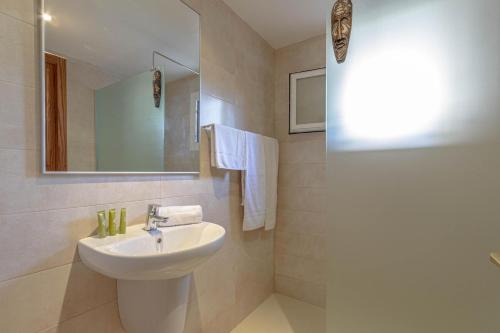 a white bathroom with a sink and a mirror at PINOS ALTOS 11 in Cala de Sant Vicenc