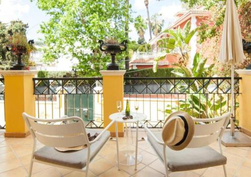 a patio with two chairs and a table with a hat at BYPILLOW Villa Lorena Adults Recommended in Málaga