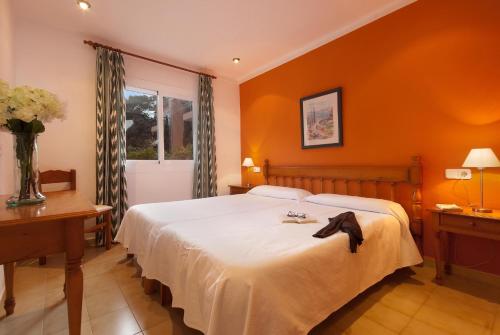 a bedroom with a large bed with an orange wall at PINOS ALTOS 16 in Cala de Sant Vicenc