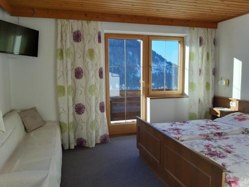 a bedroom with a bed and a large window at Bommerhof in Waidring