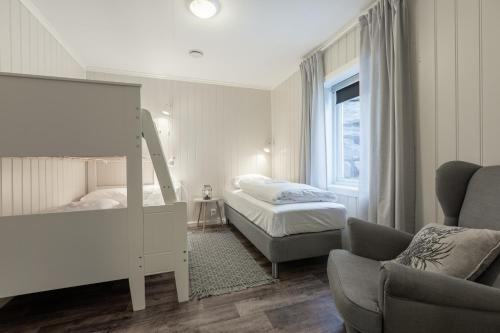 1 dormitorio con 2 camas, silla y espejo en SAGI 5 Apartment, en Hafslo