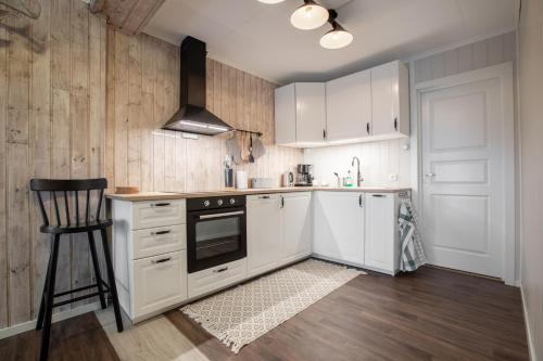 a kitchen with white cabinets and a chair in it at SAGI 5 Apartment in Hafslo