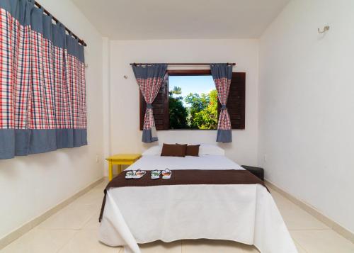 a bedroom with a bed and a window at Chalet Schönenberg in Guaramiranga