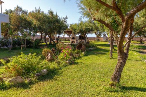 a garden with trees and flowers in a yard at Zefyros Apartments and House in Kissamos